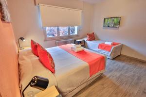 a hotel room with two beds and a couch at Hotel Bariloche By Tierra Gaucha in San Carlos de Bariloche