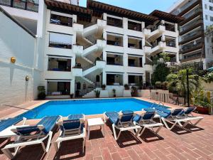 a swimming pool with lounge chairs and a building at Vallarta Sun Suites in Puerto Vallarta