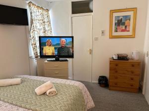 a bedroom with a flat screen tv and a bed at Northern Pearl Hotel in Blackpool
