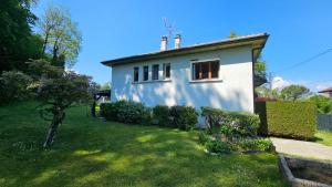 ein kleines weißes Haus mit einem grünen Hof in der Unterkunft Villa La Moraine in Thonon-les-Bains