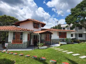 a house with a grass yard in front of it at Villa Mimosa Finca Hotel in Quimbaya