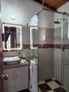 y baño con ducha y lavamanos. en Villa Mimosa Finca Hotel en Quimbaya