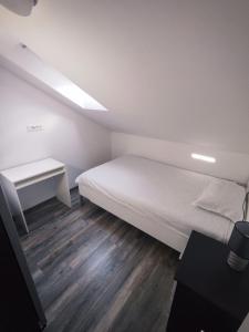 a small bedroom with a bed and a desk at Apartment Loft in Sinj