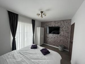- une chambre avec un lit doté de 2 oreillers violets dans l'établissement Kul House - Cazare, à Băileşti