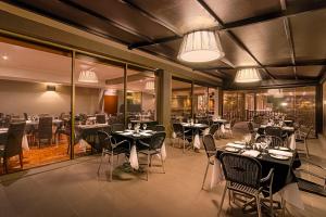 Crest on Barkly Hotel في ملبورن: غرفة طعام مع طاولات وكراسي وأضواء