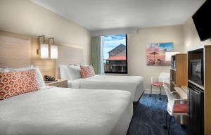 a hotel room with two beds and a window at Surfside Beach Oceanfront Hotel in Myrtle Beach