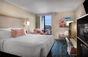 a hotel room with a bed and a balcony at Surfside Beach Oceanfront Hotel in Myrtle Beach
