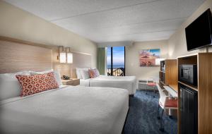 a hotel room with two beds and a television at Surfside Beach Oceanfront Hotel in Myrtle Beach