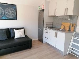 een woonkamer met een bank en een keuken bij EiraDouro - Casa Oliveira 