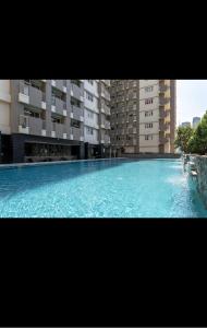 a large swimming pool with blue water in front of buildings at Laureano Trevi Residences Makati Suites Condotel in Manila