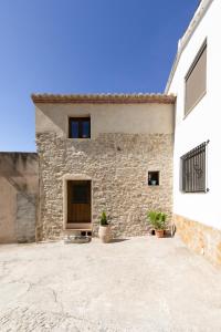 a stone building with potted plants in front of it at Casa Rural Lavadero en Teresa 