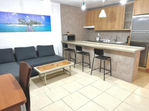 a living room with a couch and a kitchen at Appartement FUN & SUN in San Isidro