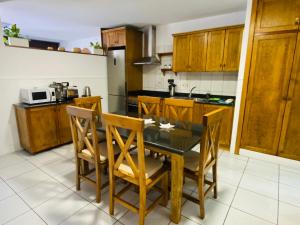 a kitchen with a table and chairs and a microwave at CASA ATLANTICO in Puerto del Carmen