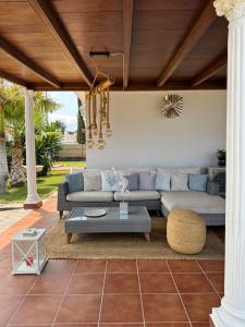 ein Wohnzimmer mit Sofa und Tisch in der Unterkunft Villa Claudia - HEATED POOL by VV Canary Ocean Homes in Puerto de Santiago