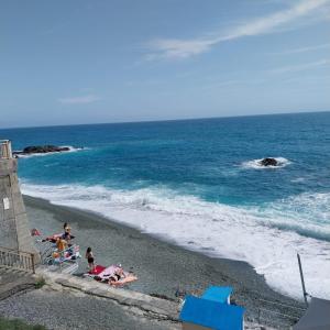 a group of people on a beach near the ocean at ANFORA HOUSE in Genoa