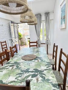 a dining room with a green table and chairs at Maison bord de mer 10 couchages in Saint-Vaast-la-Hougue
