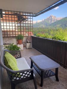 a balcony with two chairs and a table and a view at Belvedere da Cesarina in Tarvisio