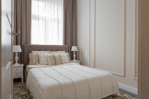 a bedroom with a white bed with a window at Apartament Veranda in Sopot