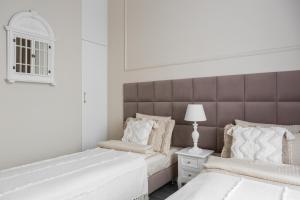 two beds in a white bedroom with a headboard at Apartament Veranda in Sopot