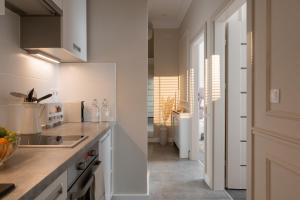 a kitchen with white cabinets and a sink at Apartament Veranda in Sopot