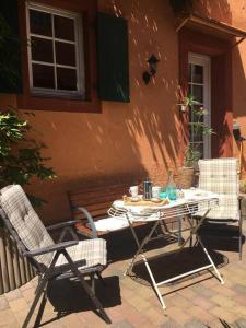 einen Tisch und Stühle außerhalb eines Gebäudes in der Unterkunft Ferienhaus im Haus der Künste in Rhodt unter Rietburg