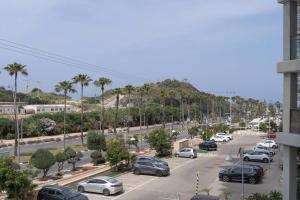 a street with cars parked in a parking lot at Unique beach apartment in Rishon LeẔiyyon