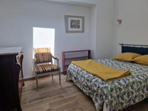 um quarto com uma cama e uma cadeira em Mon beau village em Lecques