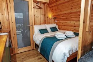 1 dormitorio con 1 cama en una cabaña de madera en The Highland Bothies Glamping, en Ullapool