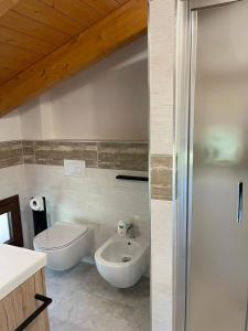 a bathroom with a white toilet and a sink at B&B Del Corso in SantʼAgata Bolognese