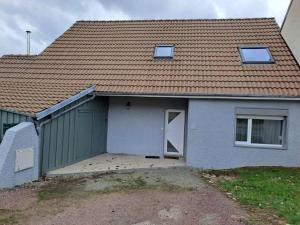 a house with a garage and a house with a roof at Gîte Les Pareurs in La Ferté-Macé