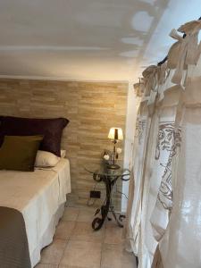1 dormitorio con 1 cama y 1 mesa con lámpara en Le Bouganvillea, en Peschici