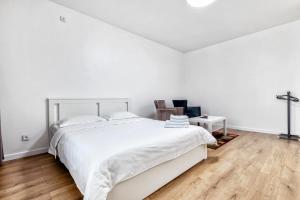una camera bianca con un letto bianco e un pavimento in legno di Raisson Ahotel GT79 a Astana