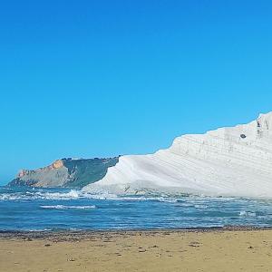 a beach with a white iceberg in the ocean at apartament scala dei turchi e Piscina in Realmonte