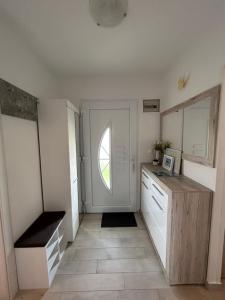 cocina con armarios blancos y puerta con ventana en Apartment Salov, en Trogir