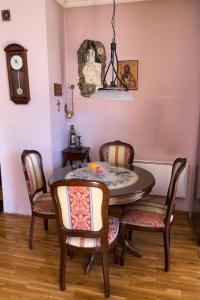 ein Esszimmer mit einem Tisch, Stühlen und einer Uhr in der Unterkunft Apartment Filip in Bar
