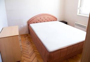 Bett in einem Zimmer neben einem Holztisch in der Unterkunft Apartment Filip in Bar