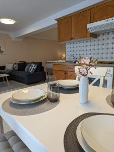 a kitchen with a table with plates and flowers on it at Tor zur Teufelsschlucht in Ferschweiler +17 photos