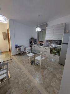 a kitchen with a table and chairs and a refrigerator at B&B LA GIARA ART in Gallipoli