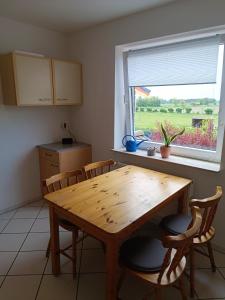 a kitchen with a wooden table and chairs and a window at Ferienwohnung Almdorf in Almdorf