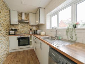 a kitchen with white cabinets and a sink at North Harbour House in Weymouth