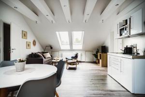 cocina y sala de estar con mesa blanca y sillas en DachtRaum Waldner en Würzburg