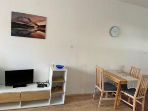 sala de estar con escritorio, TV y mesa en Apartmani Gojko, en Biograd na Moru