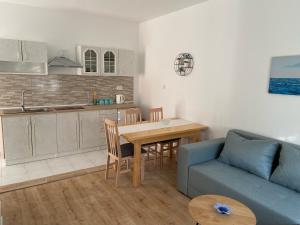 sala de estar con sofá, mesa y cocina en Apartmani Gojko, en Biograd na Moru