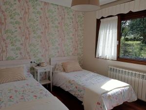 um quarto com 2 camas e uma janela em Marlada Playa de Poo de Llanes em Po