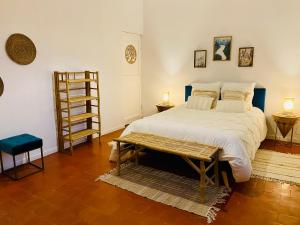een slaapkamer met een groot bed en een houten tafel bij Le Mas d’Aloha in Plan-dʼOrgon
