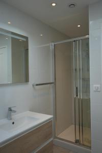 biała łazienka z prysznicem i umywalką w obiekcie Maison contemporaine aux portes de Brest w mieście Bohars