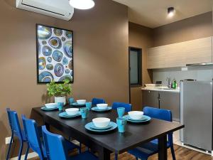 a dining room with a table and blue chairs at Alpha LaVista at Emira Residence Shah Alam in Shah Alam