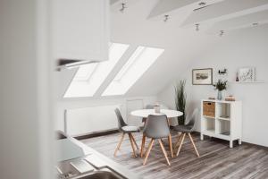 une salle à manger blanche avec une table et des chaises dans l'établissement DachtRaum Waldner, à Wurtzbourg