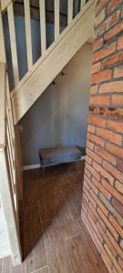 a bench sitting under a staircase with a brick wall at ORYNKA chatka w Malinnikach in Malinniki