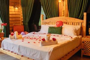 a bedroom with a bed with two wooden dolls on it at Kackarsan Vip wooden Suites in Rize